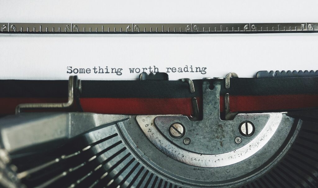 Close-up of a vintage typewriter with the phrase 'Something worth reading'.